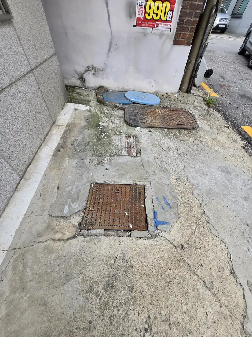 경기권 건물 뒤편 주차 공간 오수맨홀 뚜껑 여러 개 개방 점검